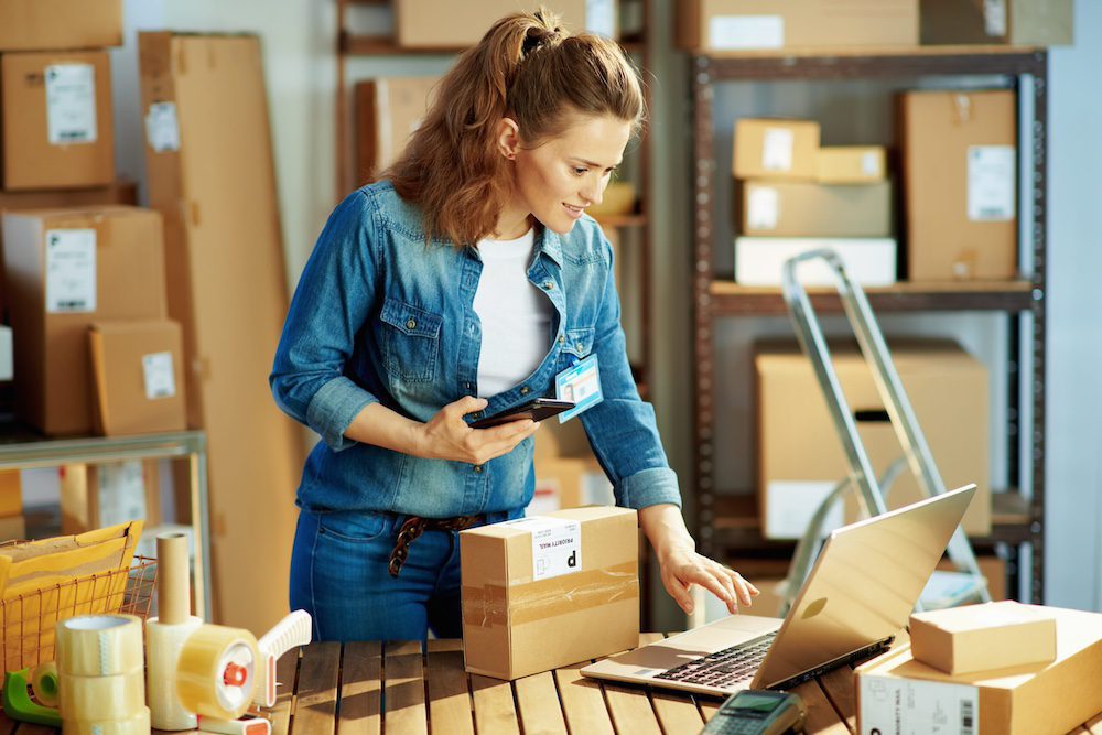 A woman in a denim shirt is standing in a warehouse