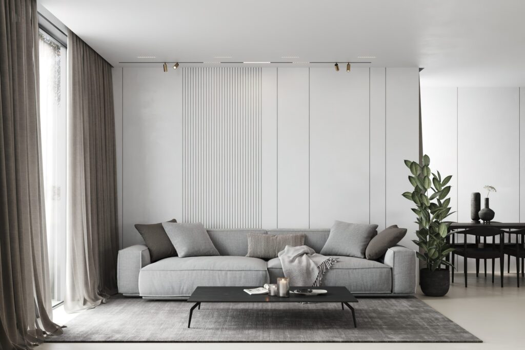 A modern living room with a gray sofa adorned with cushions and a throw blanket.