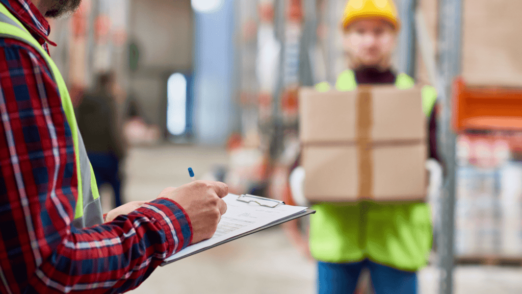 A person in a reflective vest holds a clipboard and pen in the foreground