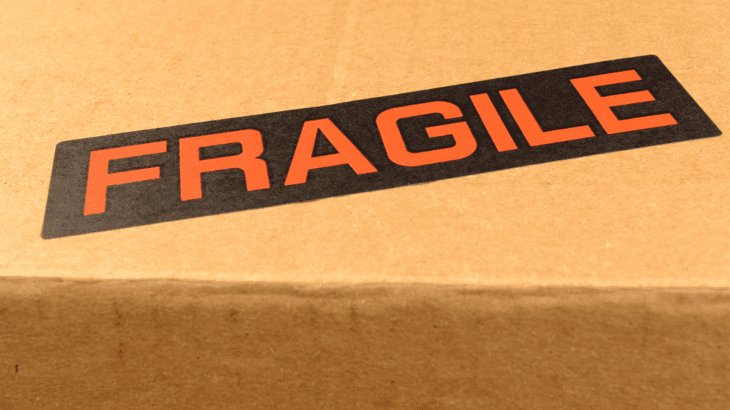 A cardboard box with a Fragile shipping label on top