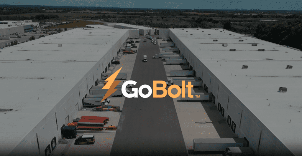 Image de la cour de l'entrepôt GoBolt avec des camions en retrait des portes du quai de chargement, superposée par le logo GoBolt