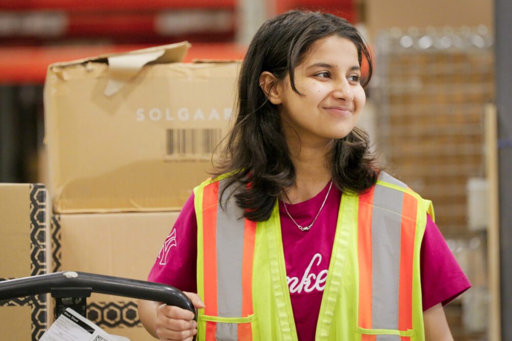 An image of a female GoBolt warehouse employee with a Solgaard box in the background