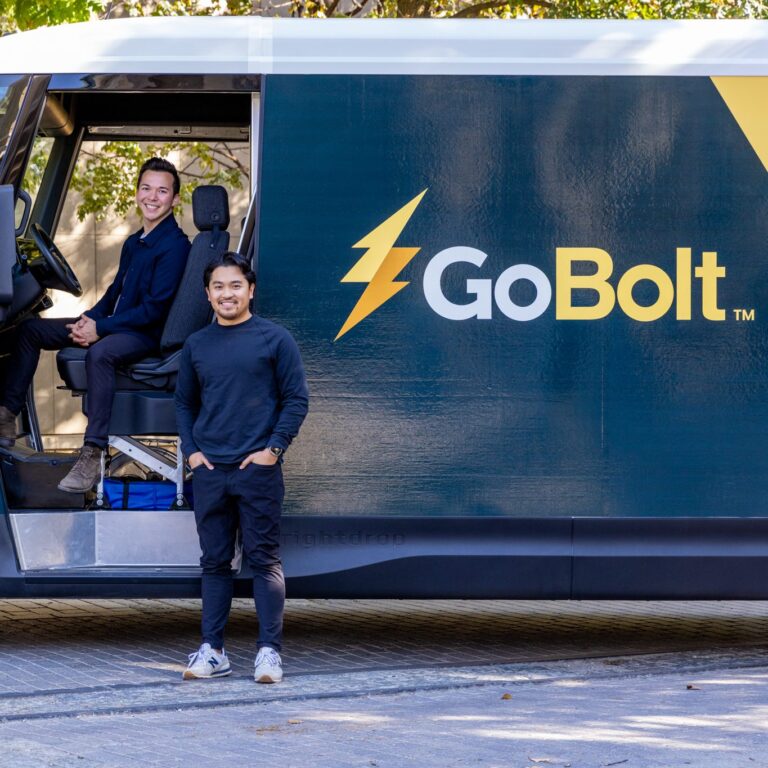A photo of Mark Ang and Heindrik Bernabe standing in front of a GoBolt electric vehicle